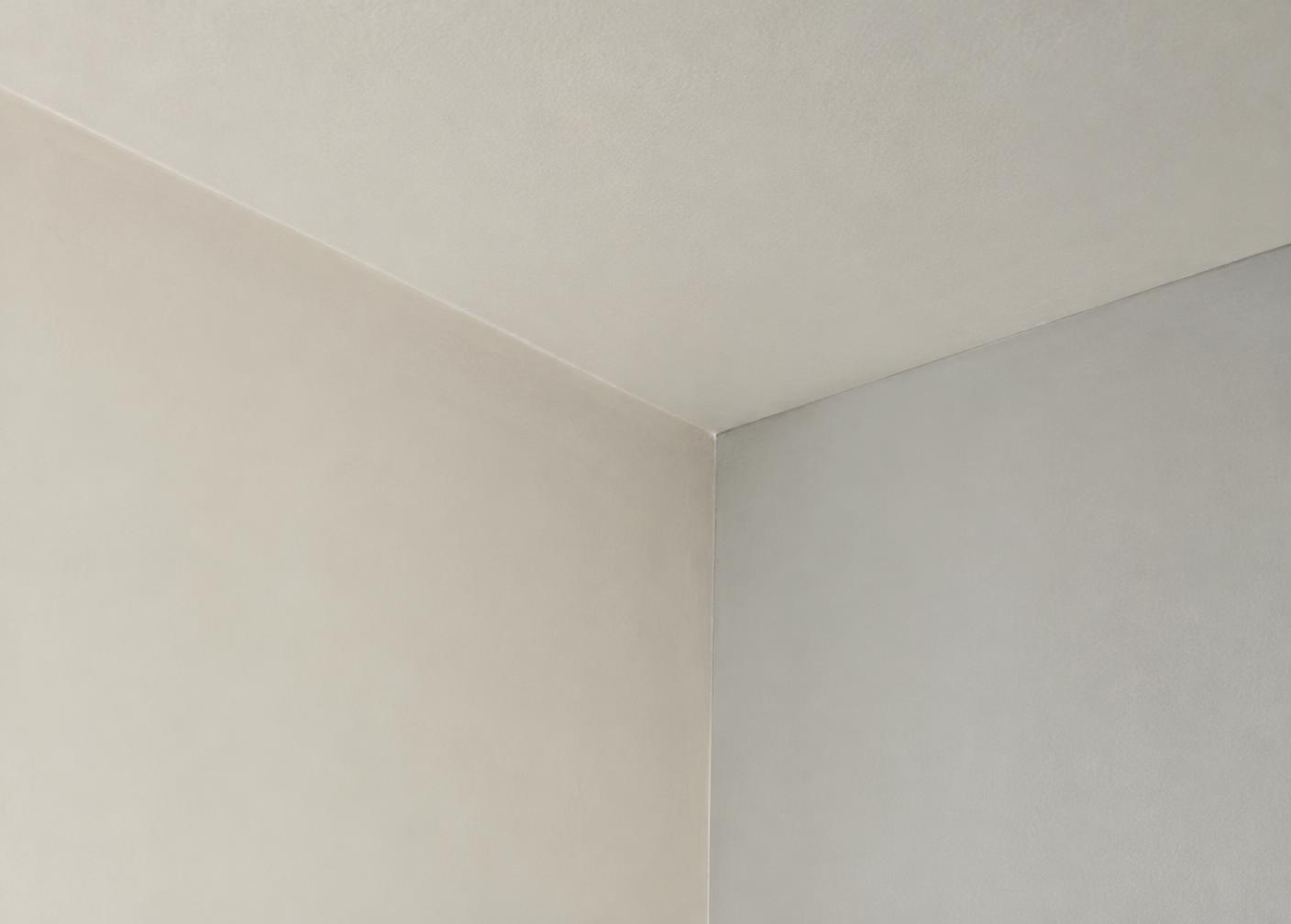 Finished drywall corner meeting a ceiling in soft light